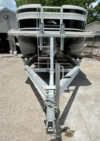 Slide: The Image of 2021 Bennington L 24 Swingback pontoon boat on a trailer in a driveway. - 31
