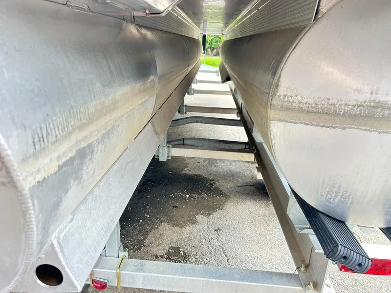Slide: The Image of Underneath view of a 2021 Bennington L 24 Swingback pontoon boat on a trailer. - 33