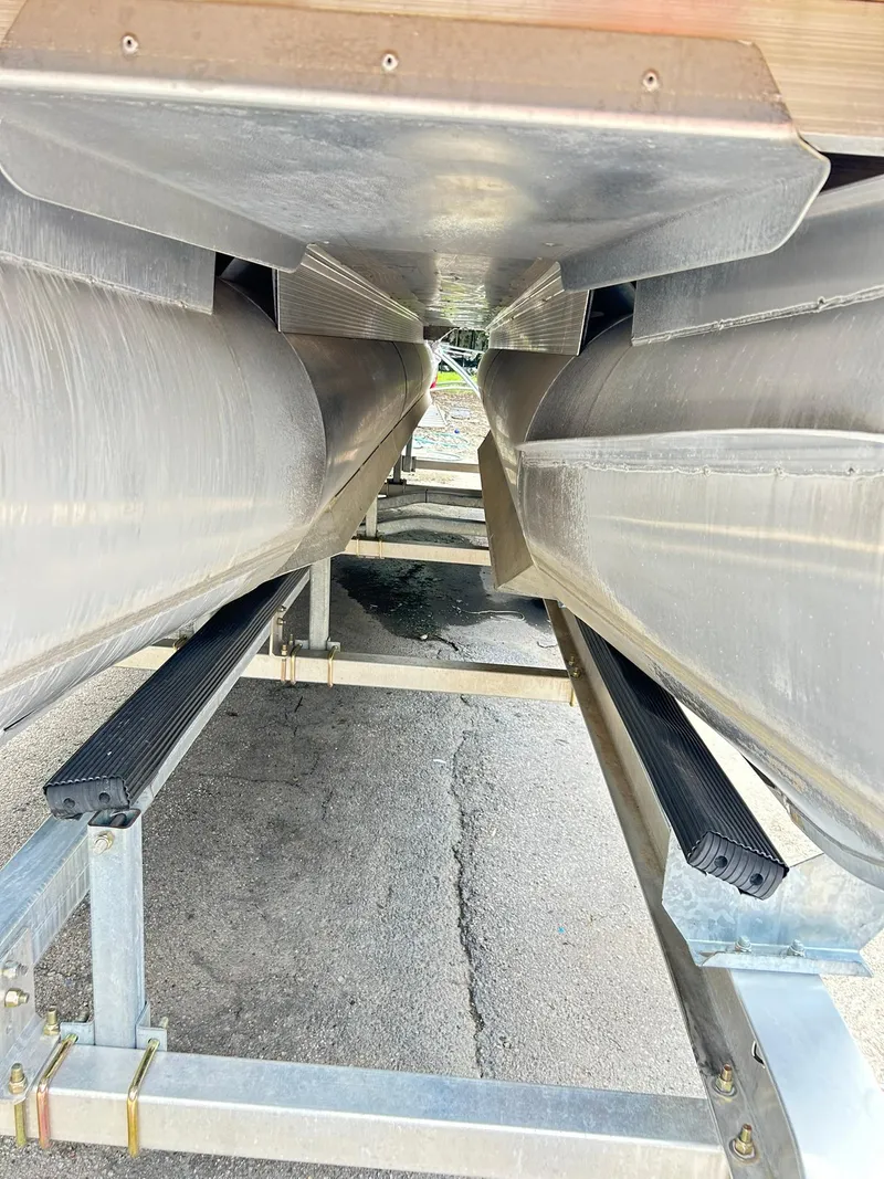 Slide: The Image of Underneath view of a 2021 Bennington L 24 Swingback pontoon boat on a trailer. - 35