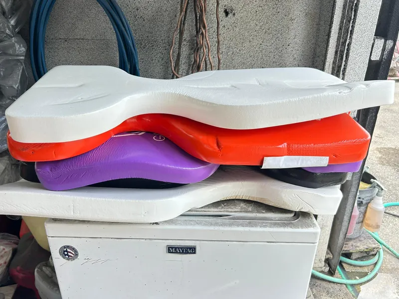 Slide: The Image of Stacked colorful foam cushions on a Maytag appliance in a garage. - 42