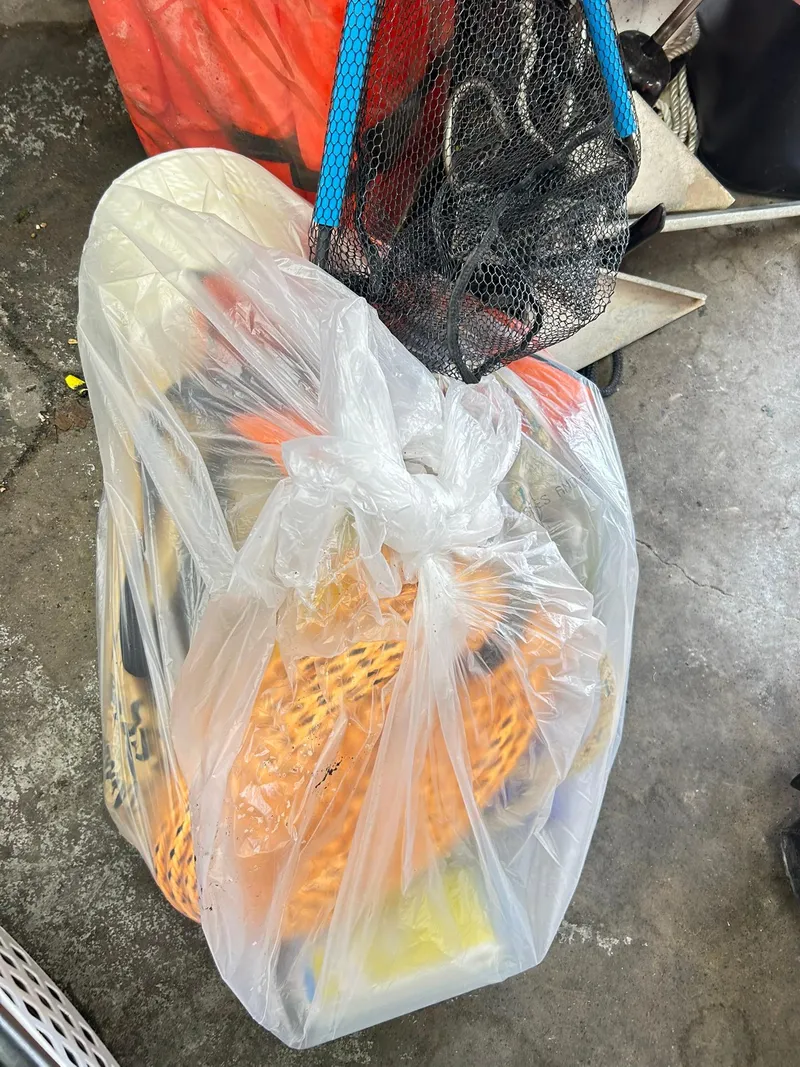 Slide: The Image of Plastic bag with assorted items, including orange netting, on a concrete floor. - 45