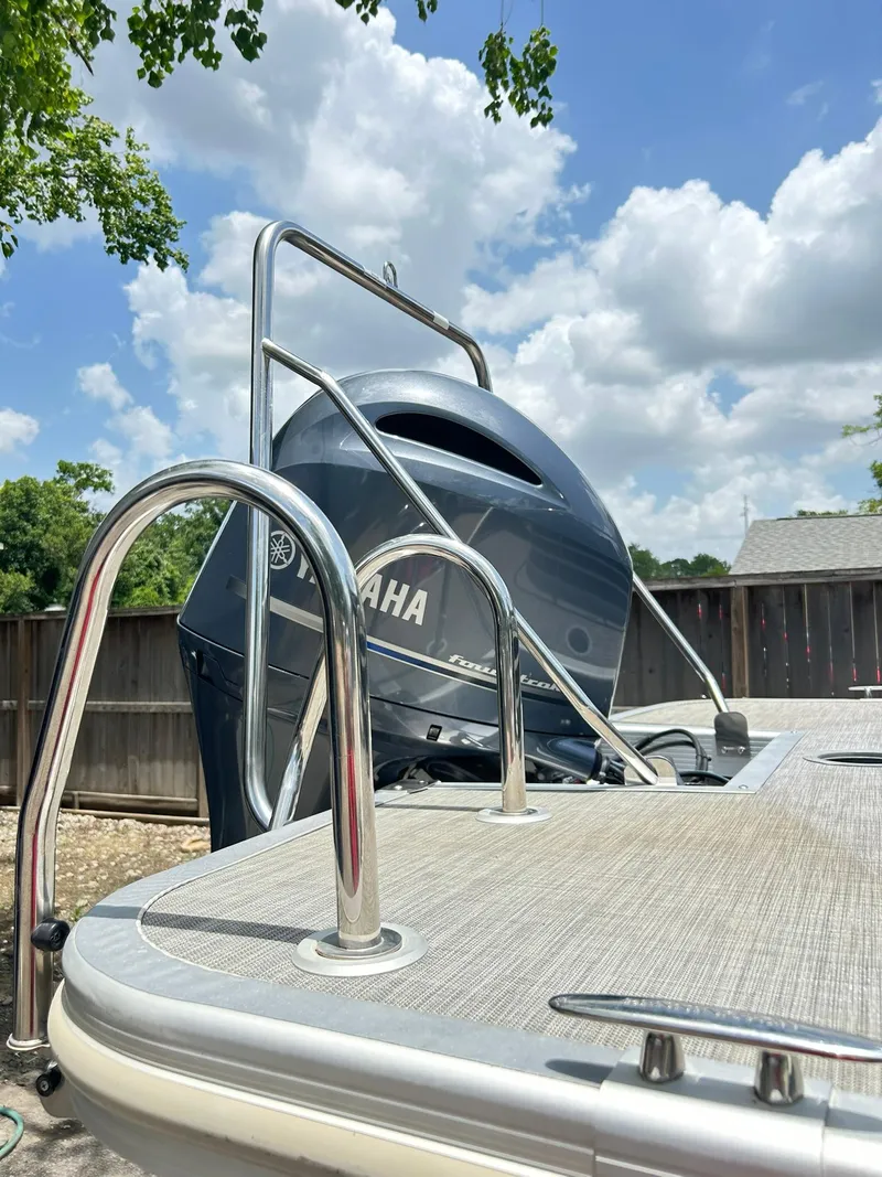 Slide: The Image of 2021 Bennington L 24 Swingback boat with Yamaha engine, under a clear blue sky. - 7