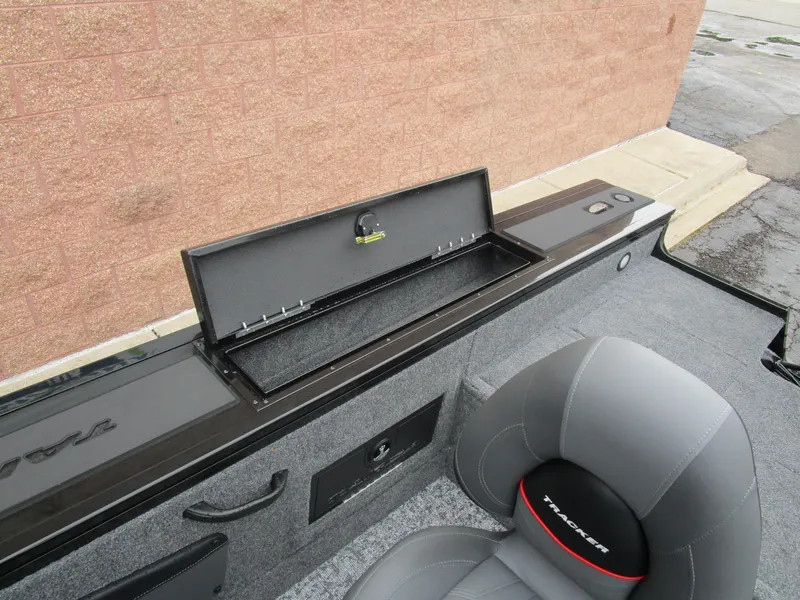 Slide: The Image of 2026 Tracker Targa 18 WT boat interior with open storage compartment and gray seating. - 14