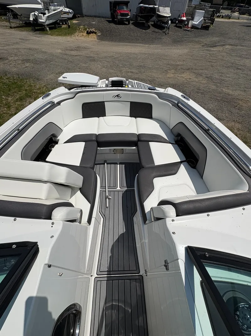 Slide: The Image of 2020 Monterey M65 boat interior with white and black seating, docked outdoors. - 13