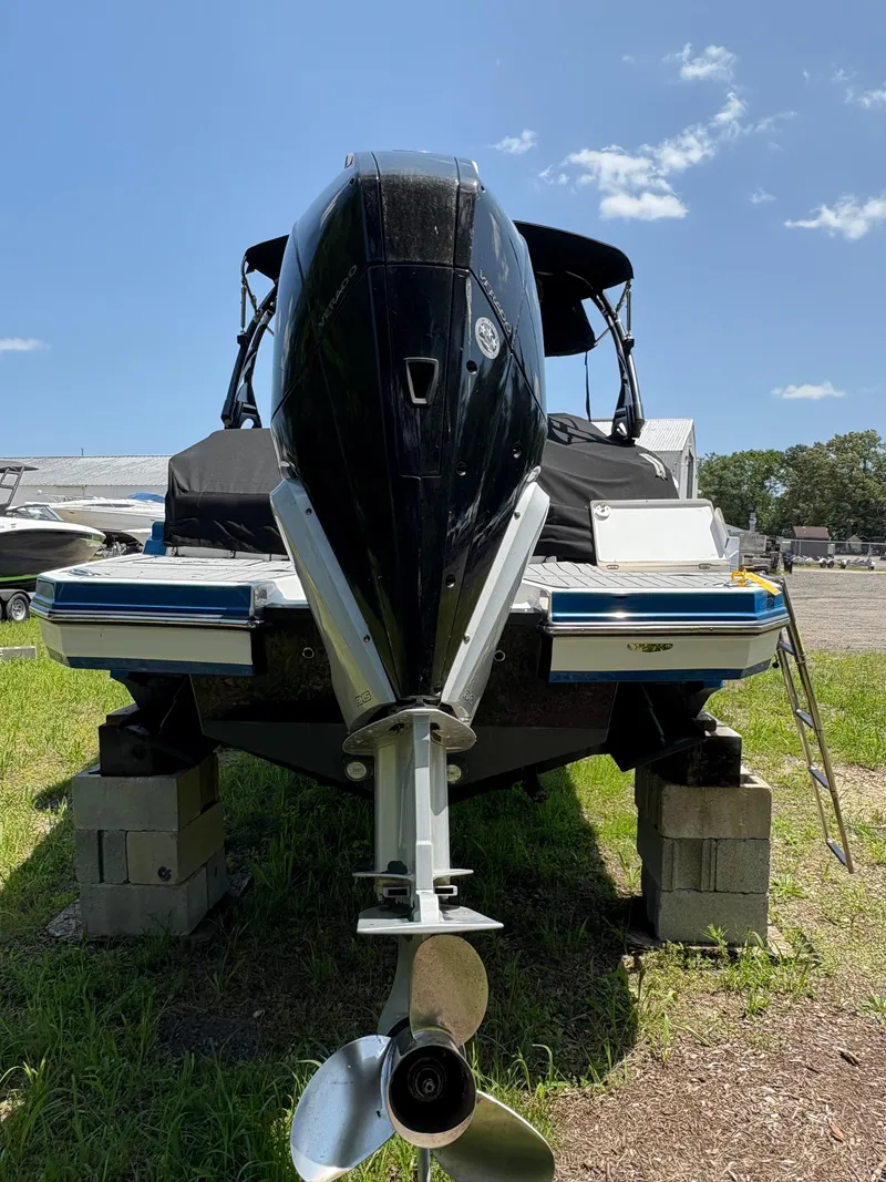 Slide: The Image of 2020 Monterey M65 boat on blocks, rear view with outboard motor, under clear blue sky. - 6