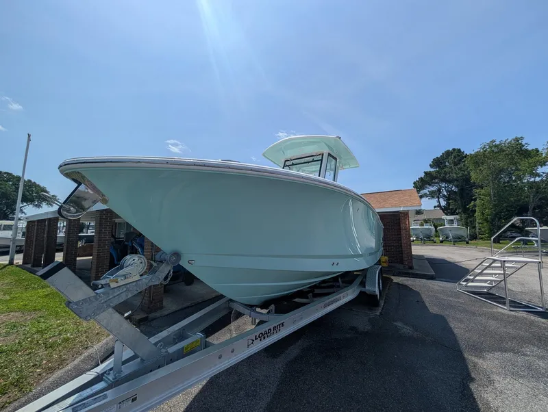 Slide: The Image of 2025 Robalo R250 Center Console boat on trailer under clear blue sky. - 3