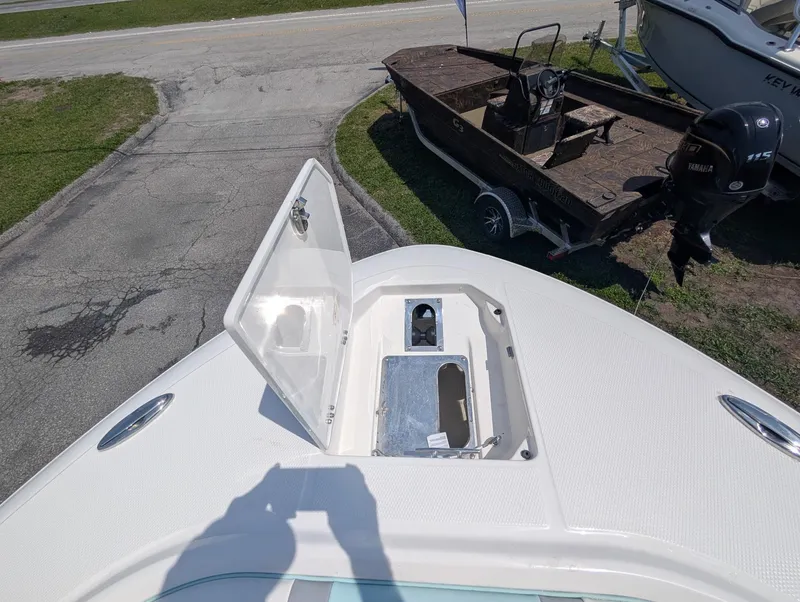 Slide: The Image of 2025 Robalo R250 Center Console boat with open storage compartment on deck. - 17