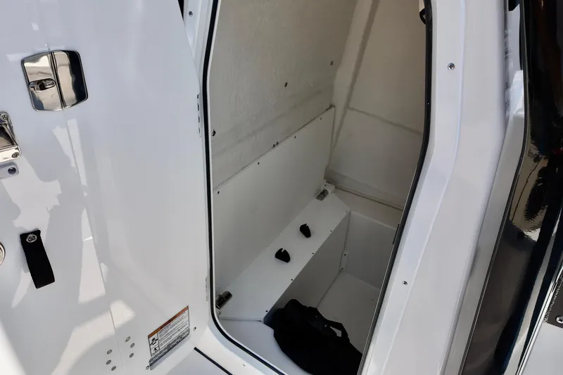 Slide: The Image of 2026 Sea Fox 231 Bay Fox interior storage compartment with white finish and secure latch. - 17