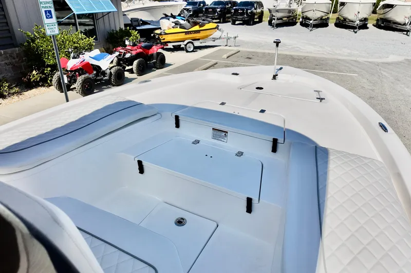 Slide: The Image of 2026 Sea Fox 231 Bay Fox boat interior with storage compartments, parked near ATVs and trailers. - 20