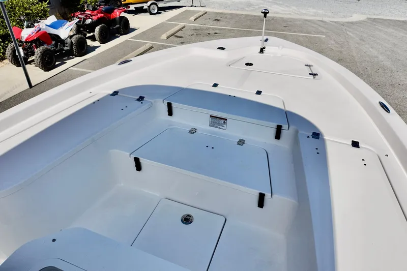 Slide: The Image of 2026 Sea Fox 231 Bay Fox boat interior with storage compartments, parked near ATVs. - 7