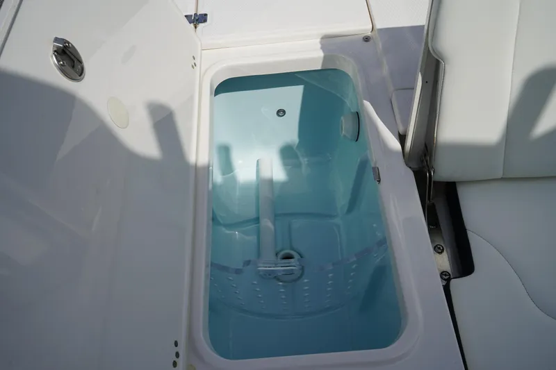 Slide: The Image of 2024 Robalo 226 Cayman boat storage compartment with open lid, showcasing interior design. - 10