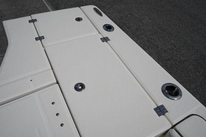 Slide: The Image of 2024 Robalo 226 Cayman boat deck with storage compartments and stainless steel fixtures. - 11