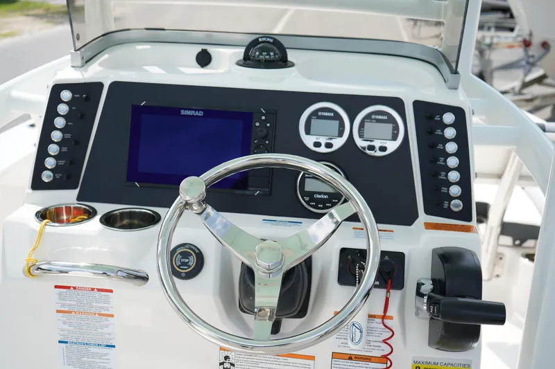 Slide: The Image of 2024 Robalo 226 Cayman boat dashboard with steering wheel and electronic controls. - 25