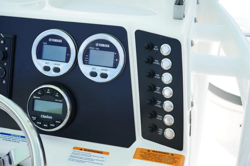 Slide: The Image of 2024 Robalo 226 Cayman dashboard with Yamaha gauges and Clarion audio controls. - 26