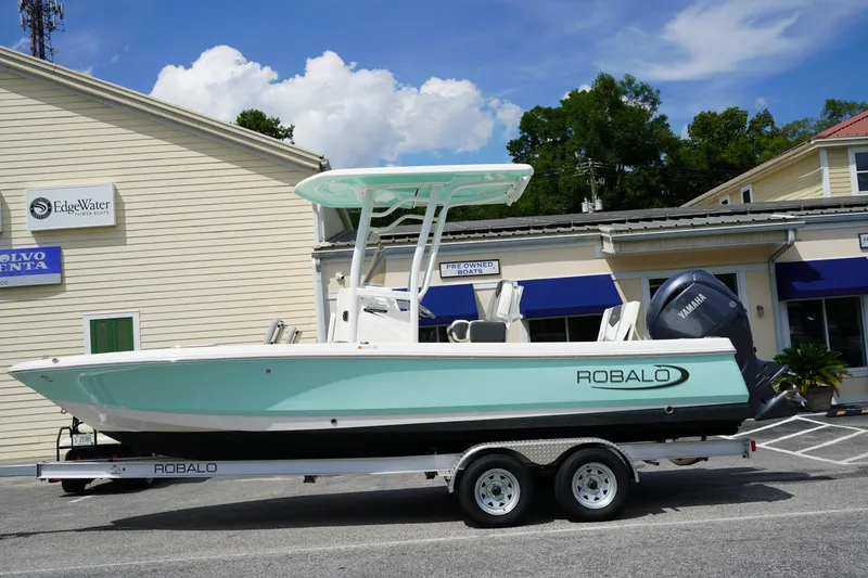 Slide: The Image of 2024 Robalo 226 Cayman boat on trailer, parked outside dealership. - 3