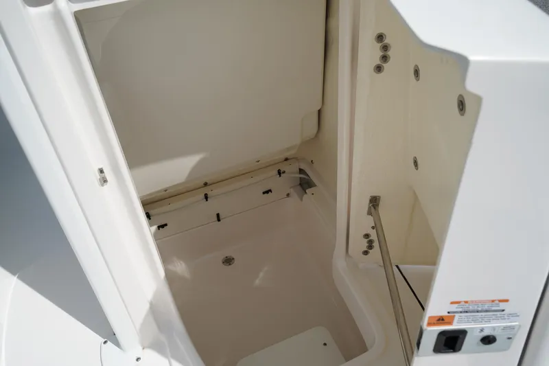 Slide: The Image of 2024 Robalo 226 Cayman boat storage compartment interior, featuring clean white finish. - 36