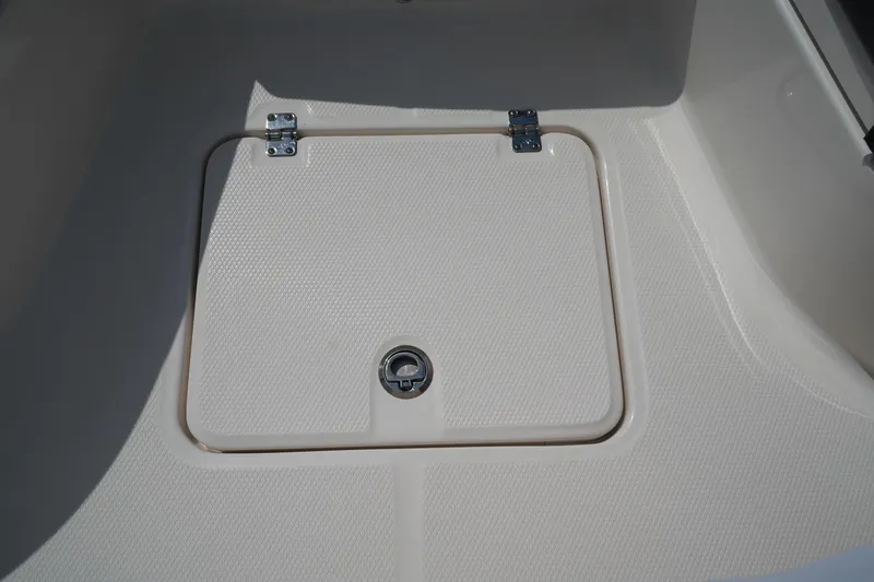 Slide: The Image of 2024 Robalo 226 Cayman boat storage compartment with textured surface and secure latch. - 37