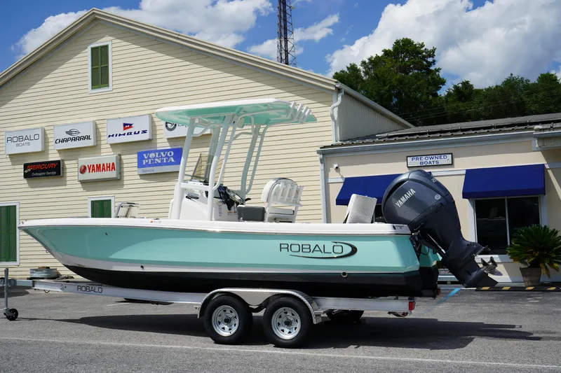 Slide: The Image of 2024 Robalo 226 Cayman boat on trailer outside dealership, featuring Yamaha engine. - 4