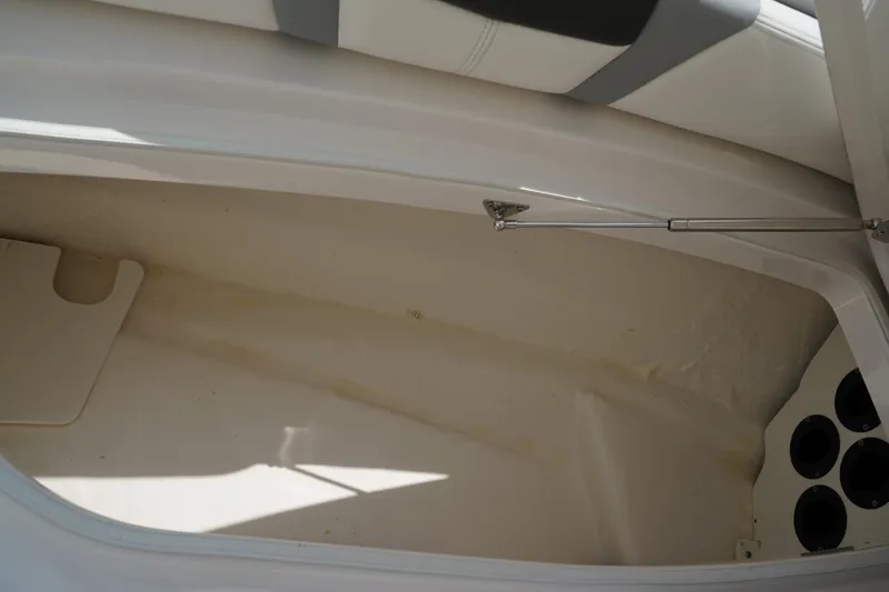 Slide: The Image of 2024 Robalo 226 Cayman storage compartment with cup holders and cushioned seating. - 44