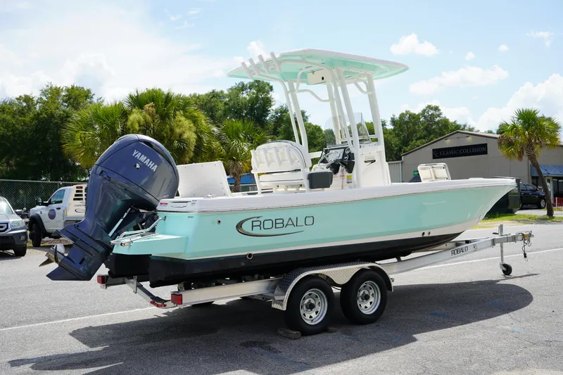 Slide: The Image of 2024 Robalo 226 Cayman boat on trailer with Yamaha engine, parked outdoors. - 5