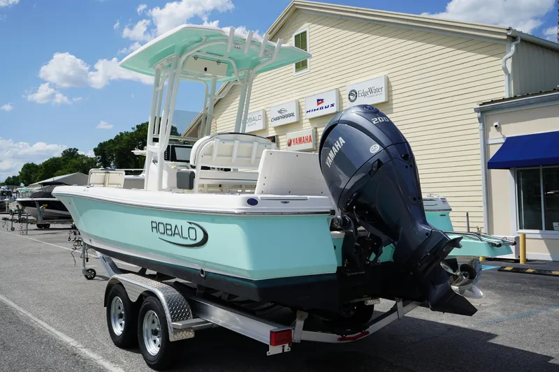 Slide: The Image of 2024 Robalo 226 Cayman boat on trailer, featuring Yamaha outboard motor, parked outdoors. - 6