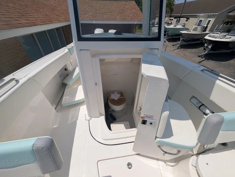 Slide: The Image of 2025 Robalo R250 Center Console boat interior with open console door and seating. - 9