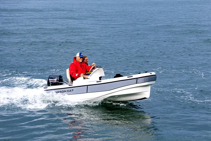 The Image of 2025 Aspen Carbon Cat boat cruising on open water with two passengers. - 0