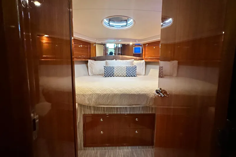 Slide: The Image of Luxurious bedroom interior of 2005 Riviera 47 Open Flybridge yacht with elegant wood finish. - 106