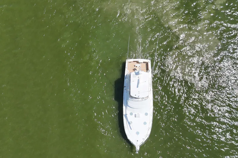 Slide: The Image of Aerial view of 2005 Riviera 47 Open Flybridge yacht cruising on green water. - 11