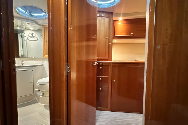 Slide: The Image of Interior of 2005 Riviera 47 Open Flybridge yacht with wooden cabinetry and bathroom. - 128