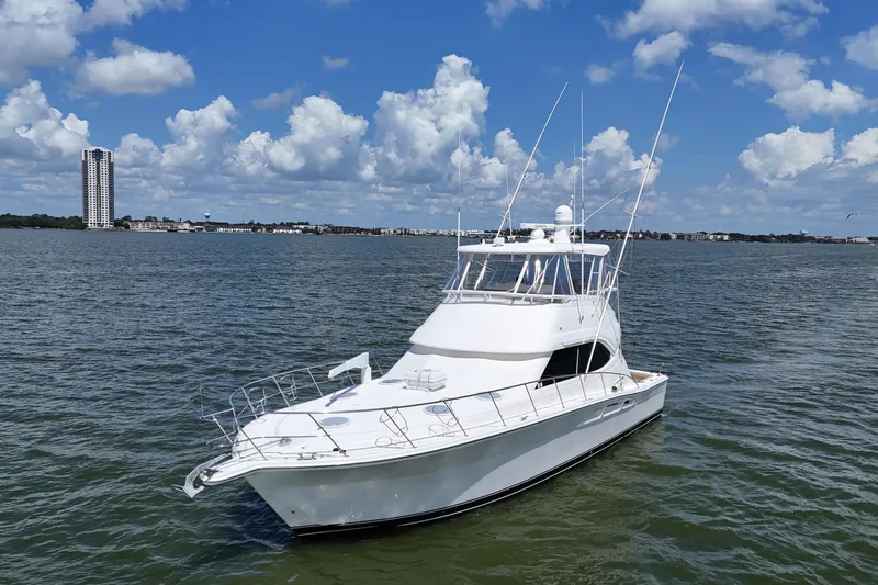 Slide: The Image of 2005 Riviera 47 Open Flybridge yacht on calm water under a blue sky. - 13
