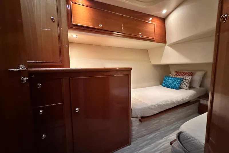 Slide: The Image of 2005 Riviera 47 Open Flybridge cabin with wooden cabinetry and cozy bedding. - 130