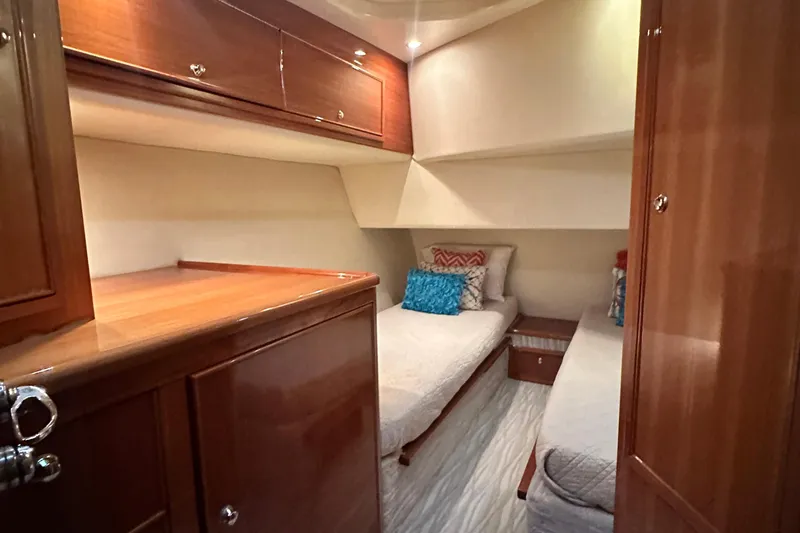 Slide: The Image of Interior of 2005 Riviera 47 Open Flybridge with twin beds and wooden cabinetry. - 131
