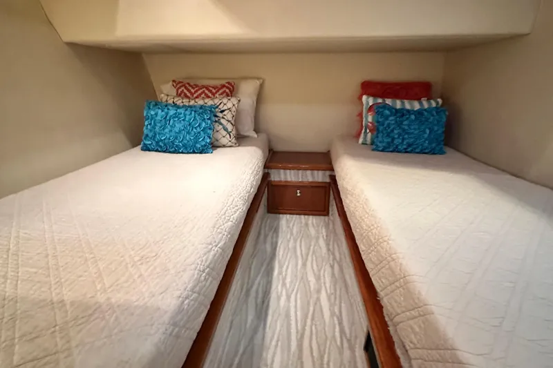 Slide: The Image of 2005 Riviera 47 Open Flybridge cabin with twin beds and colorful pillows. - 134
