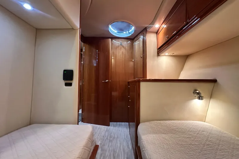 Slide: The Image of Interior of 2005 Riviera 47 Open Flybridge yacht with twin beds and wooden cabinetry. - 136