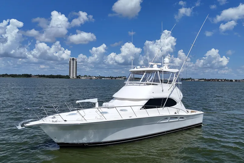 Slide: The Image of 2005 Riviera 47 Open Flybridge yacht on calm water under a blue sky. - 14
