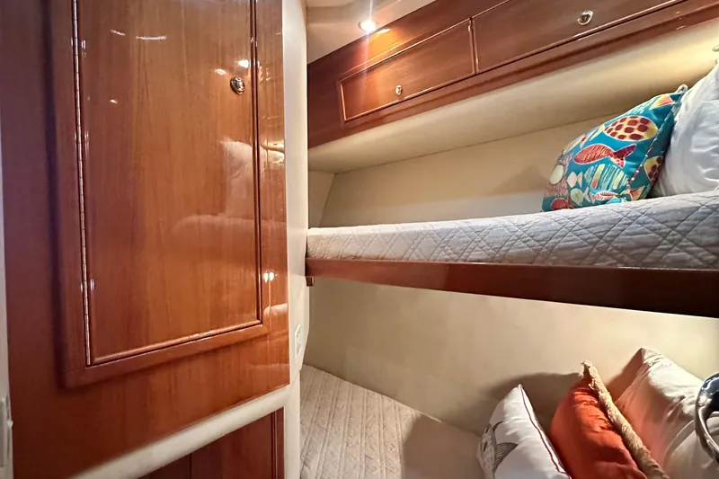 Slide: The Image of Luxurious 2005 Riviera 47 Open Flybridge cabin with cozy bunk beds and elegant wood finish. - 142