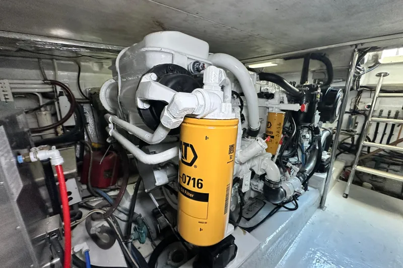 Slide: The Image of Engine room of 2005 Riviera 47 Open Flybridge with visible components and oil filter. - 157