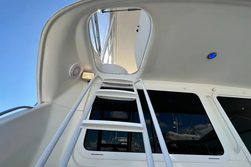 Slide: The Image of Ladder leading to flybridge on 2005 Riviera 47 Open Flybridge yacht, under clear blue sky. - 16