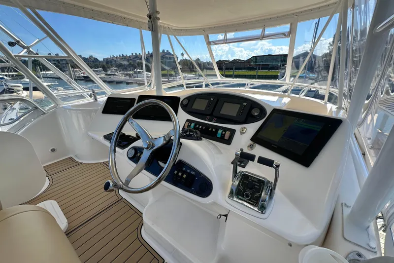 Slide: The Image of 2005 Riviera 47 Open Flybridge helm with modern navigation equipment and panoramic marina view. - 24