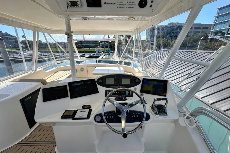 Slide: The Image of 2005 Riviera 47 Open Flybridge helm with modern navigation equipment and panoramic marina view. - 25