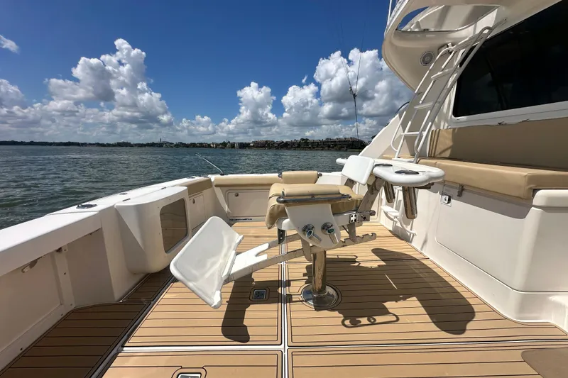 Slide: The Image of 2005 Riviera 47 Open Flybridge yacht deck with fishing chair, under a clear blue sky. - 40