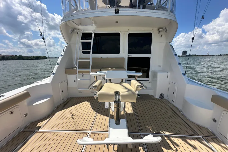 Slide: The Image of 2005 Riviera 47 Open Flybridge yacht deck with seating, overlooking serene waters and blue sky. - 42