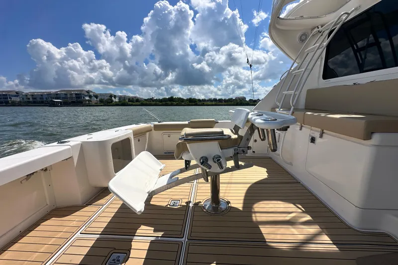 Slide: The Image of 2005 Riviera 47 Open Flybridge yacht deck with fishing chair, sunny day, scenic water view. - 45