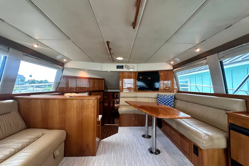 Slide: The Image of Luxurious interior of 2005 Riviera 47 Open Flybridge yacht with elegant wood finishes and seating. - 58