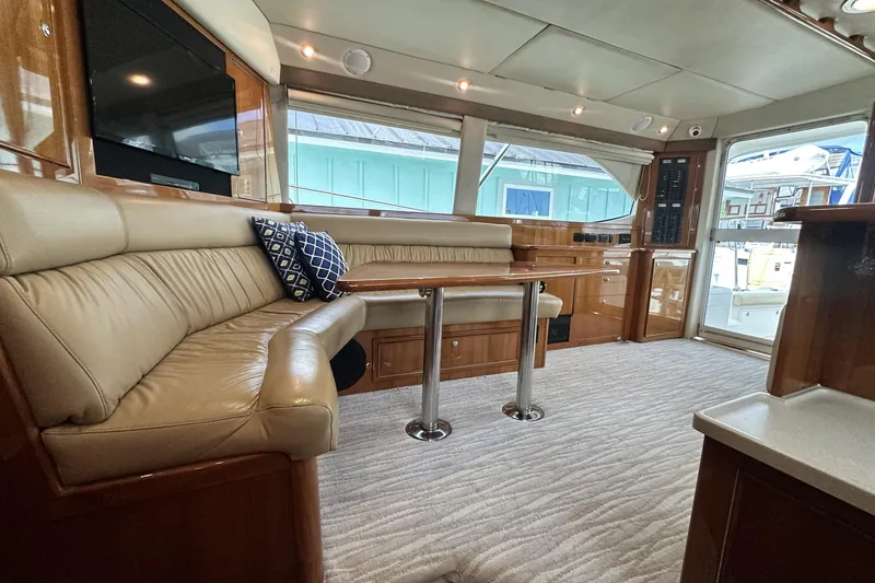 Slide: The Image of Interior of 2005 Riviera 47 Open Flybridge yacht with leather seating and wooden table. - 82