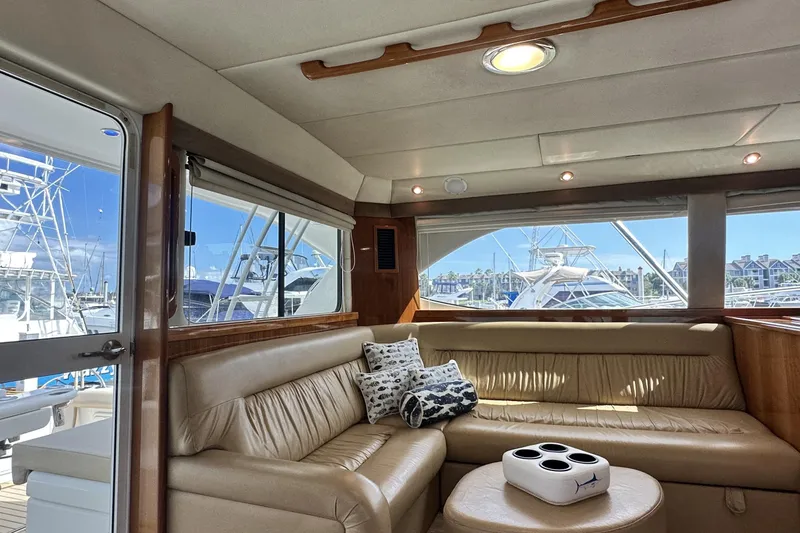 Slide: The Image of Luxurious interior of 2005 Riviera 47 Open Flybridge yacht with leather seating and marina view. - 84