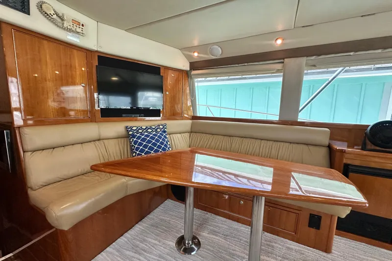 Slide: The Image of Luxurious interior of 2005 Riviera 47 Open Flybridge yacht with leather seating and wooden table. - 85