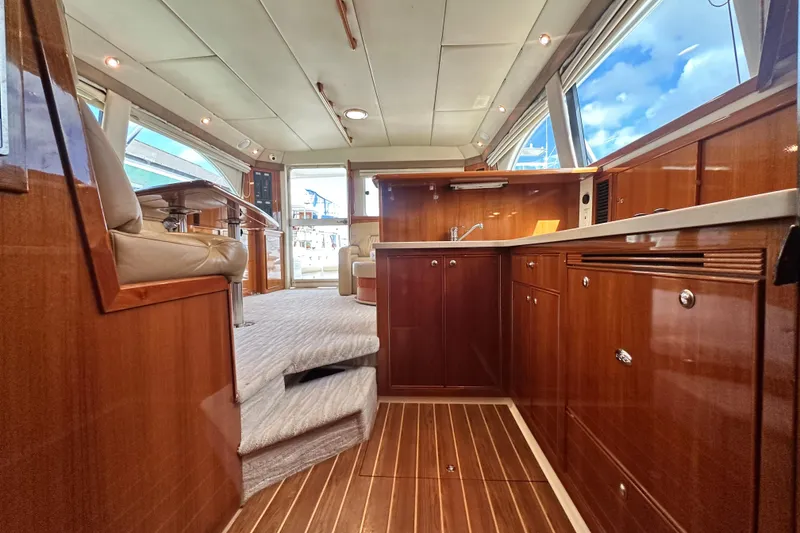 Slide: The Image of Luxurious interior of 2005 Riviera 47 Open Flybridge yacht with wooden cabinetry and plush seating. - 90