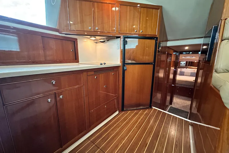 Slide: The Image of Luxurious 2005 Riviera 47 Open Flybridge yacht interior with polished wood cabinetry and modern amenities. - 96
